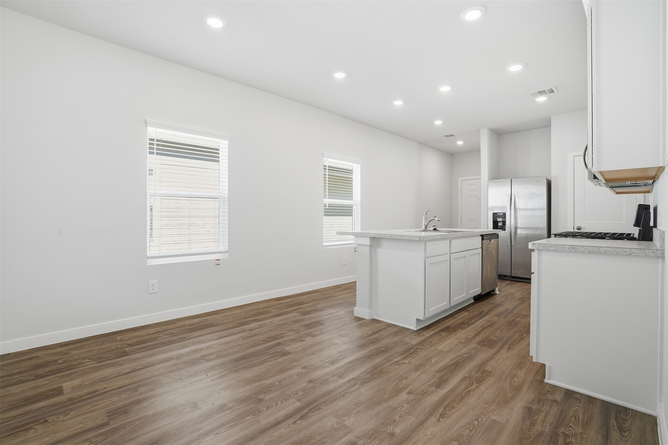16994 Pandora Way Porter, TX 77365 - Photo 17 of 25 a large white kitchen with wooden floor and a sink
