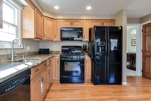 a kitchen with stainless steel appliances granite countertop a refrigerator stove and sink