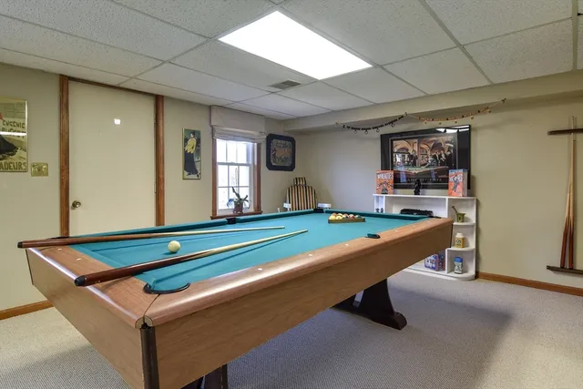 a room with pool table and windows