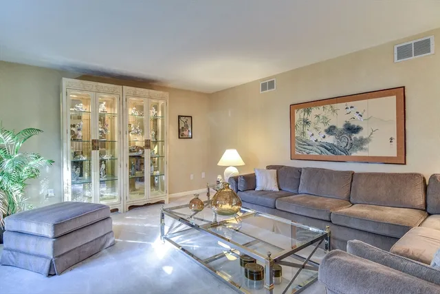 a living room with furniture a lamp and a potted plant