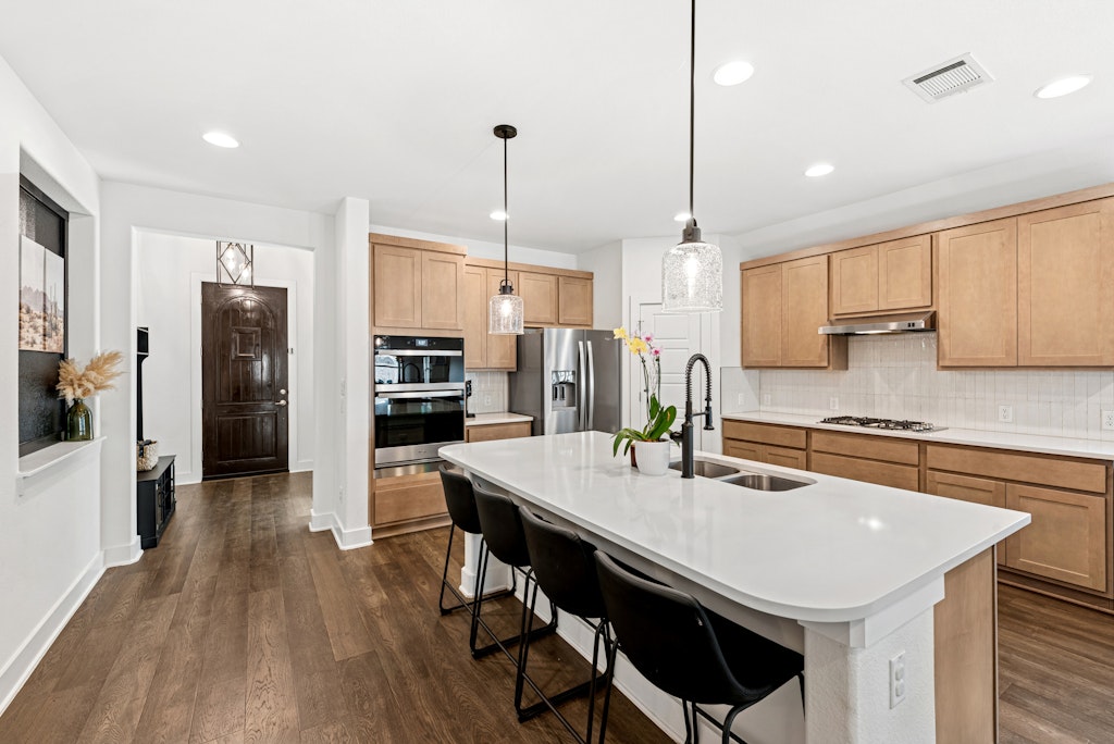 113 Wake Lane Georgetown, TX 78633 - Photo 6 of 33 a kitchen with stainless steel appliances a dining table chairs stove refrigerator and microwave