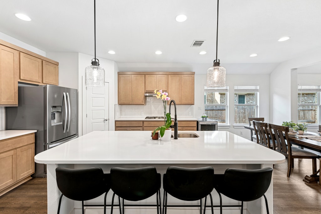 113 Wake Lane Georgetown, TX 78633 - Photo 7 of 33 a kitchen with stainless steel appliances a dining table chairs refrigerator and cabinets