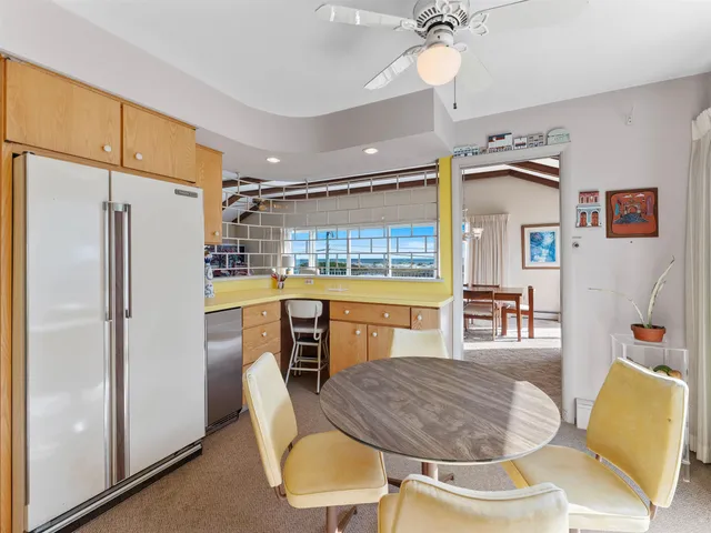 a kitchen with kitchen island a stove a table and chairs