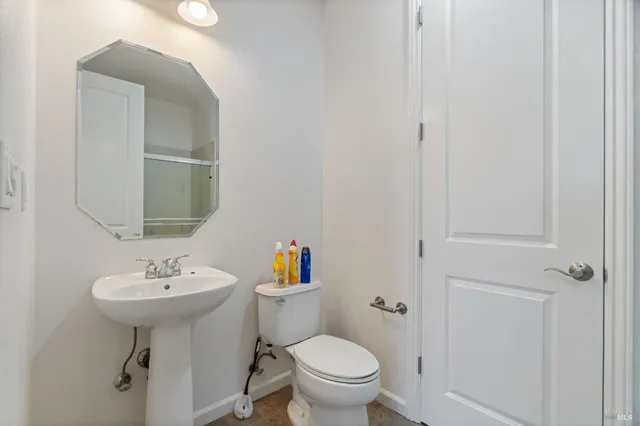 a bathroom with a sink toilet and a mirror