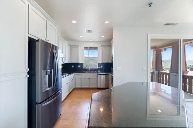 a kitchen with stainless steel appliances granite countertop a refrigerator and a sink