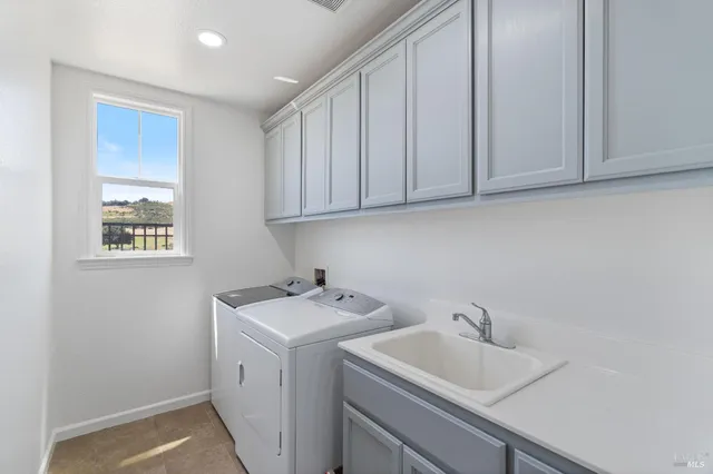 a utility room with sink dryer and washer
