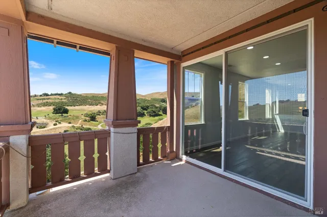 an aerial view of residential houses with a yard and mountain view in back