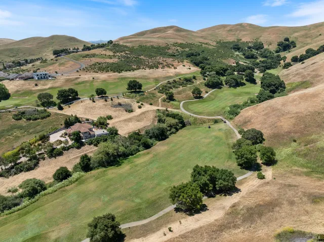 a view of a field with mountains in the background