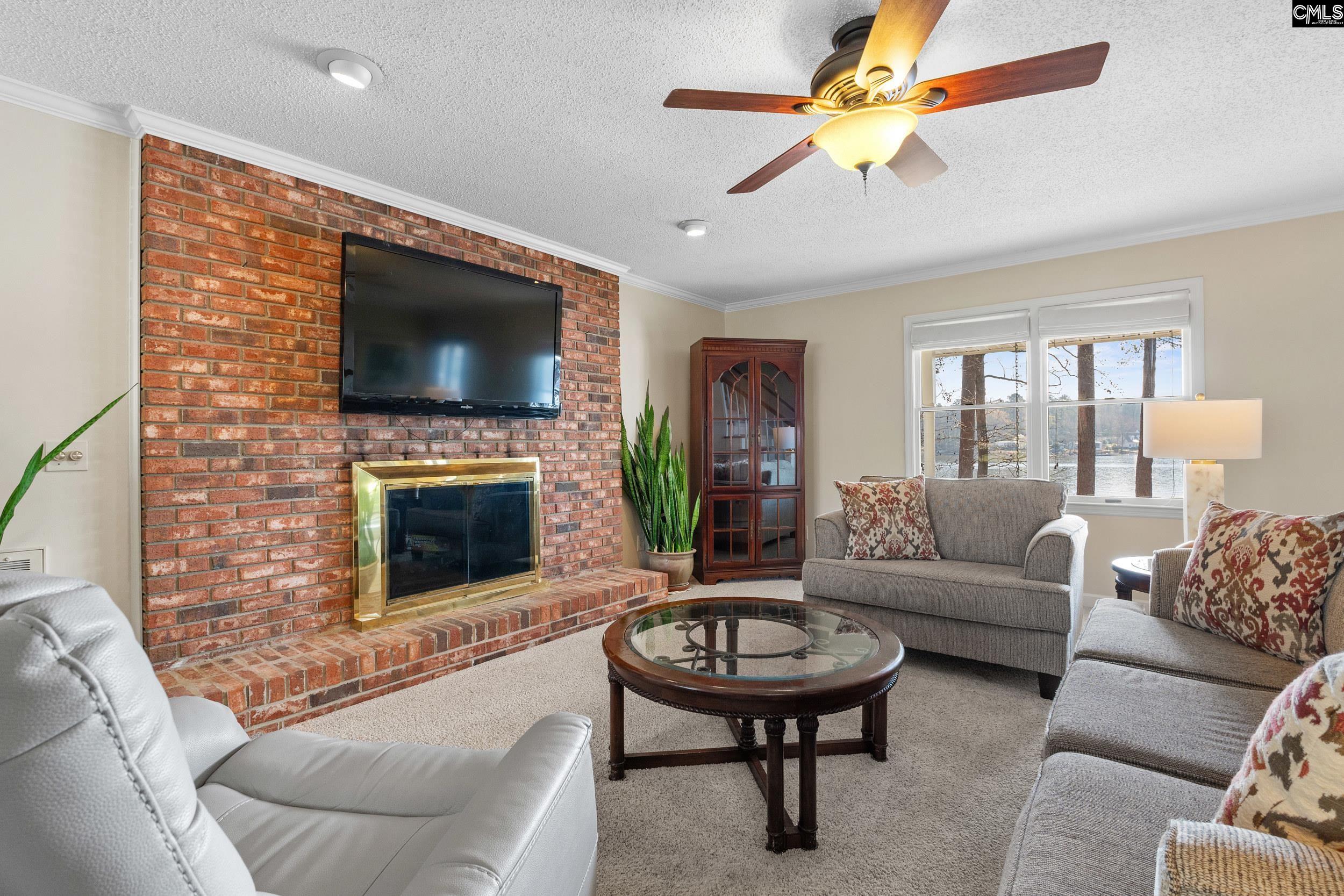 115 Rocky Ridge Road Leesville, SC 29070 - Photo 10 of 51 a living room with furniture a fireplace and a flat screen tv