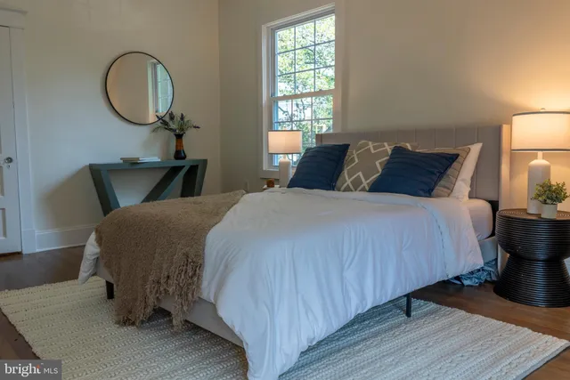 a bed room with a bed a window and dresser