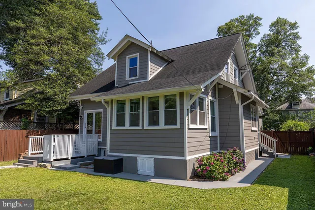 a front view of a house with a yard and potted plants
