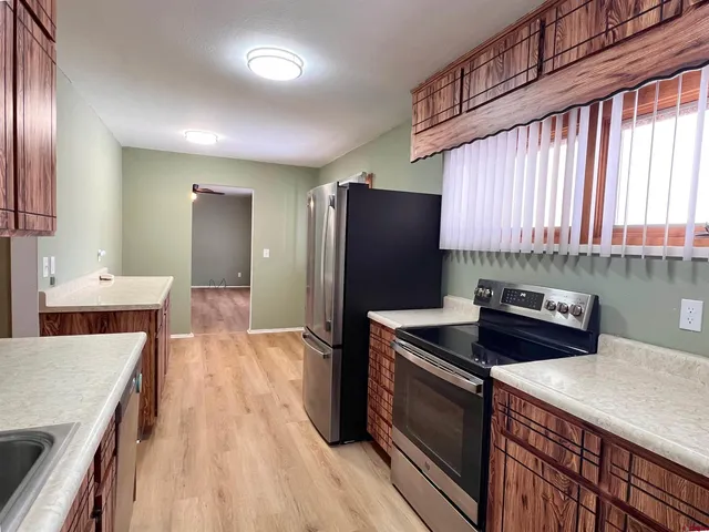 a kitchen with stainless steel appliances granite countertop a sink a stove and refrigerator