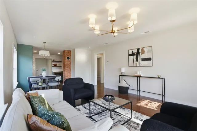 a living room with furniture a rug and kitchen view