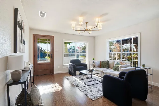 a living room with furniture wooden floor and a large window