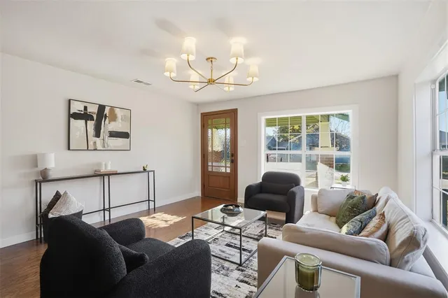 a living room with furniture a chandelier and a window