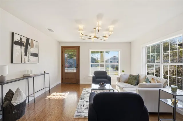 a living room with furniture and a chandelier