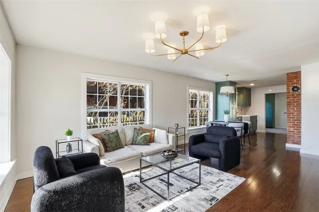 a living room with furniture a ceiling fan and a window
