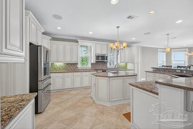 a kitchen with kitchen island granite countertop a sink cabinets and window