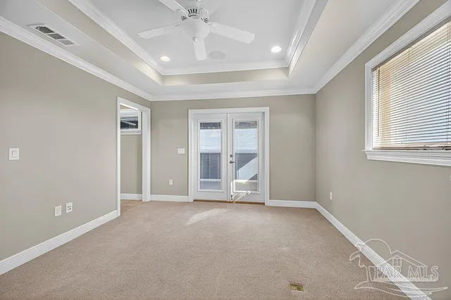 an empty room with windows and fan