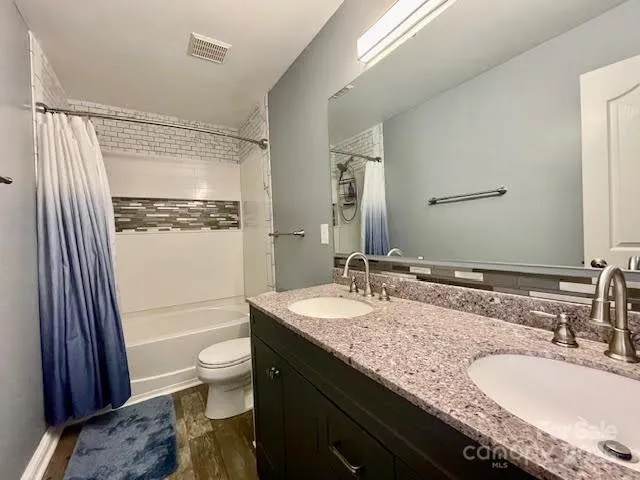 a bathroom with a granite countertop sink toilet and shower