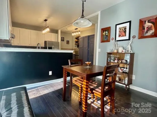 a kitchen with stainless steel appliances granite countertop a table chairs and a refrigerator
