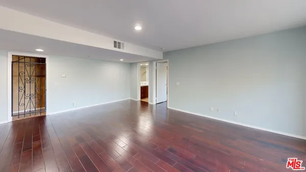 a view of empty room with wooden floor