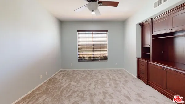 a view of empty room with window and cabinet