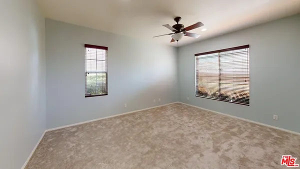 a view of a livingroom with a ceiling fan and window