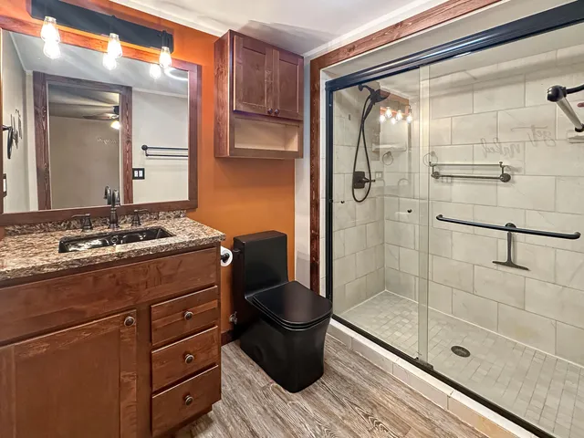 a bathroom with a sink a toilet and shower