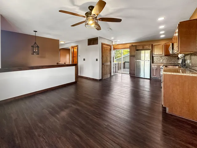 a view of a livingroom with furniture a ceiling fan and wooden floor