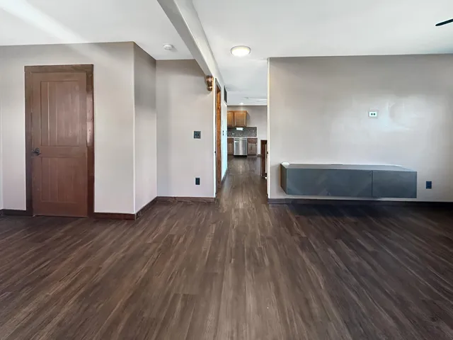 a view of empty room with wooden floor