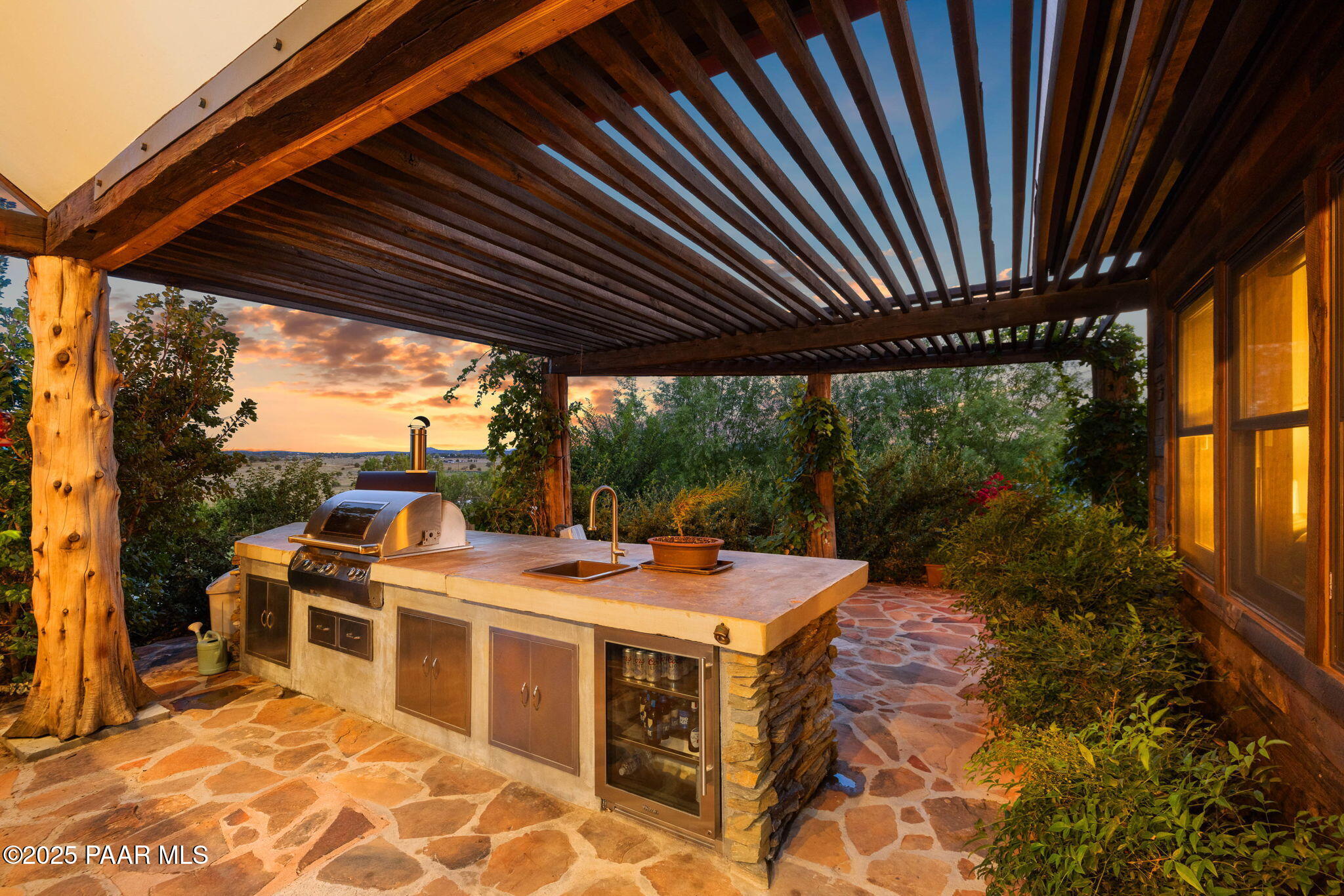 14800 North Puntenney Road Prescott, AZ 86305 - Photo 70 of 100 a view of a patio with table and chairs under an umbrella with a barbeque grill