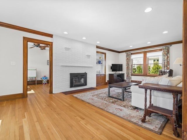 a living room with furniture a fireplace and a floor to ceiling window