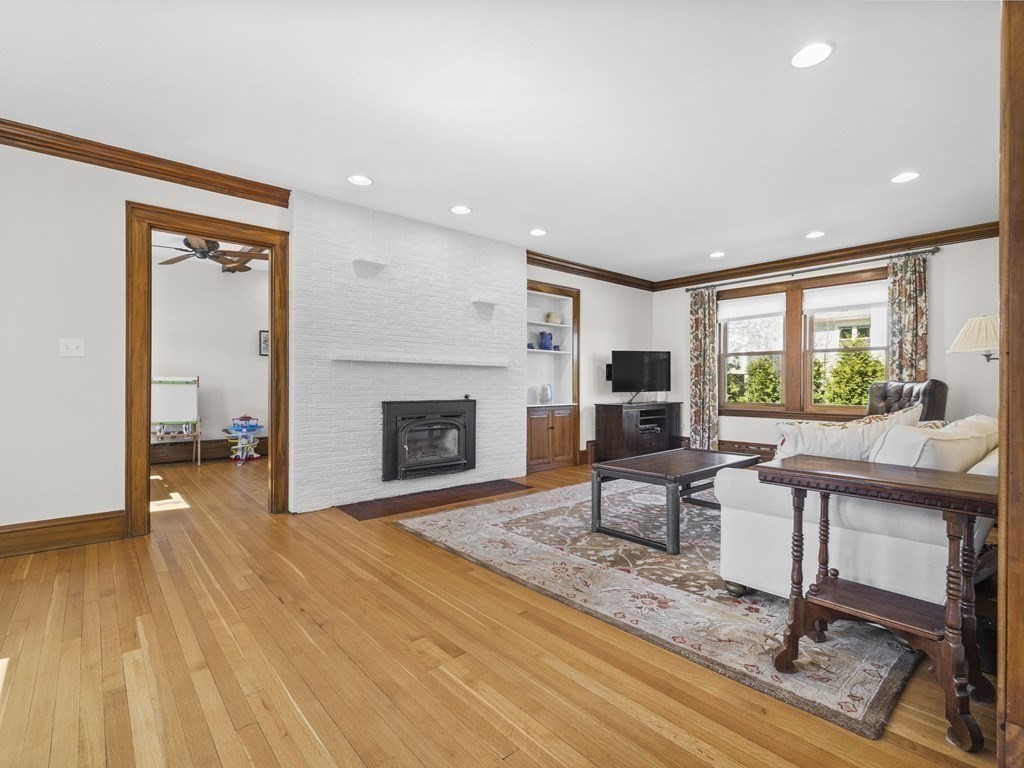 21 Normandy Road Newton, MA 02466 - Photo 2 of 36 a living room with furniture a fireplace and a floor to ceiling window