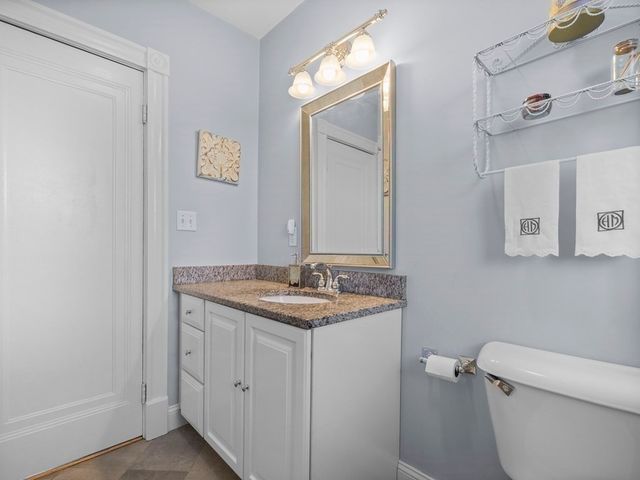a bathroom with a granite countertop toilet sink and mirror