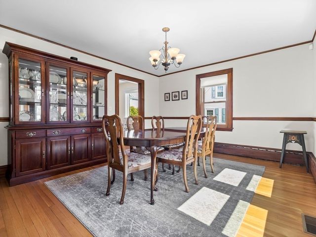 a view of a dining room with furniture a chandelier and wooden floor