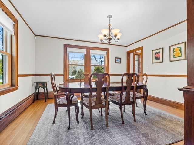 a view of a dining room with furniture a chandelier and wooden floor
