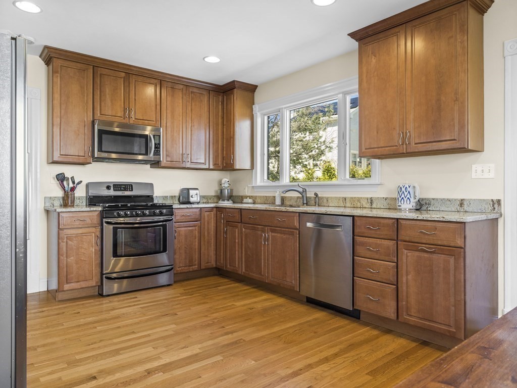 21 Normandy Road Newton, MA 02466 - Photo 7 of 36 a kitchen with granite countertop wooden cabinets stainless steel appliances and a window