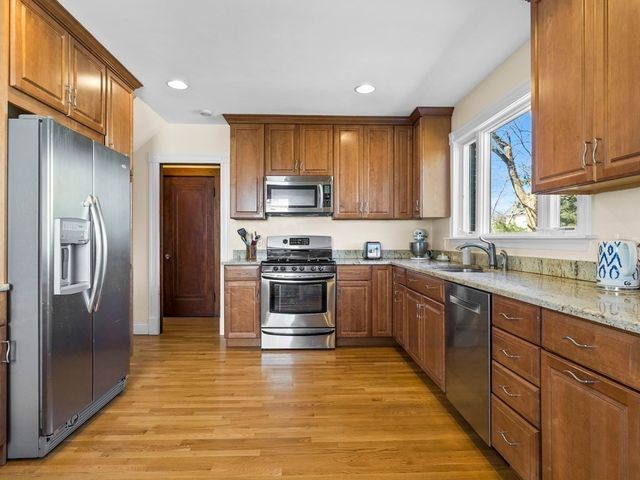 a kitchen with granite countertop a refrigerator stove top oven and sink