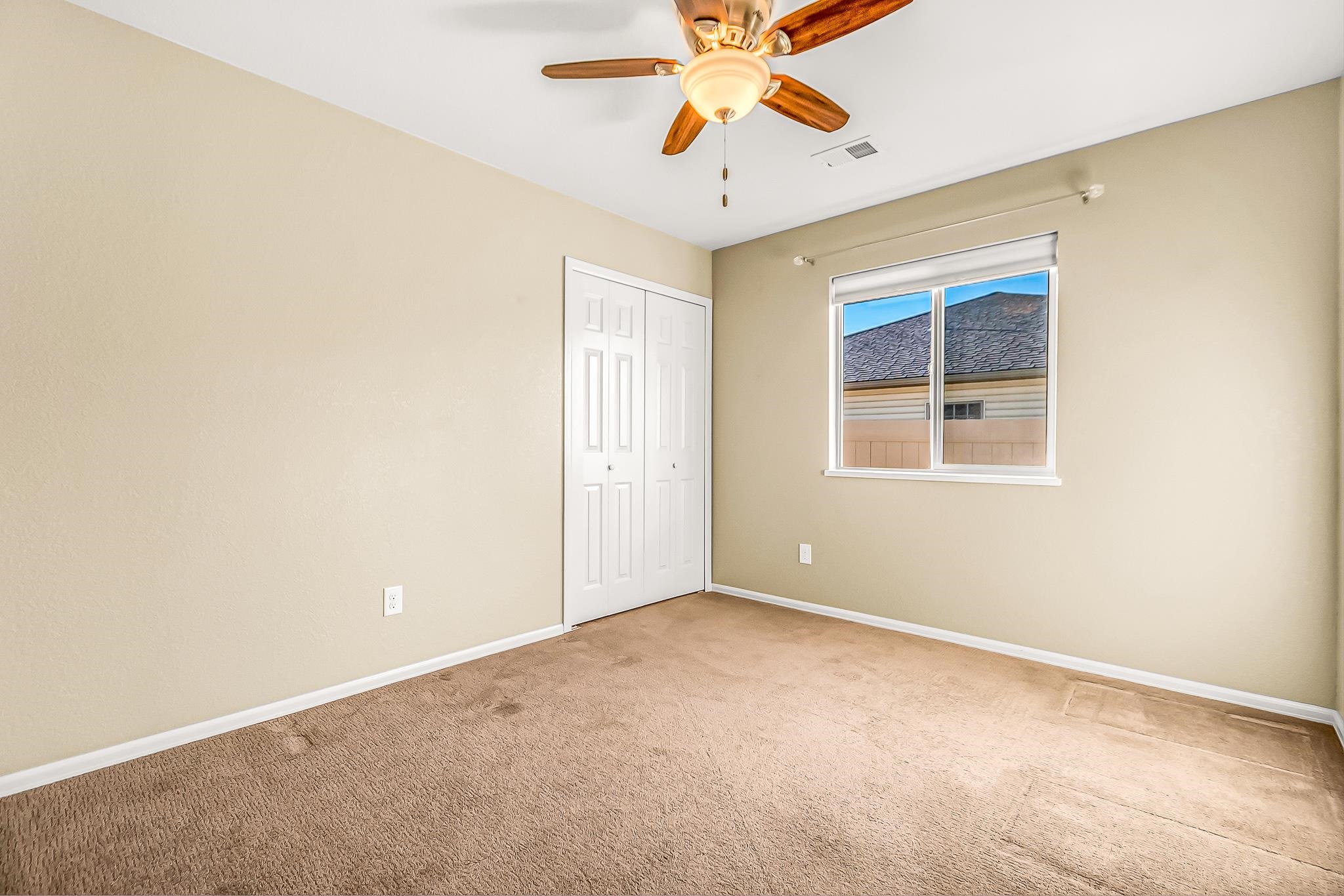120 Red Rocks Street Fruita, CO 81521 - Photo 17 of 28 an empty room with a window and a fan