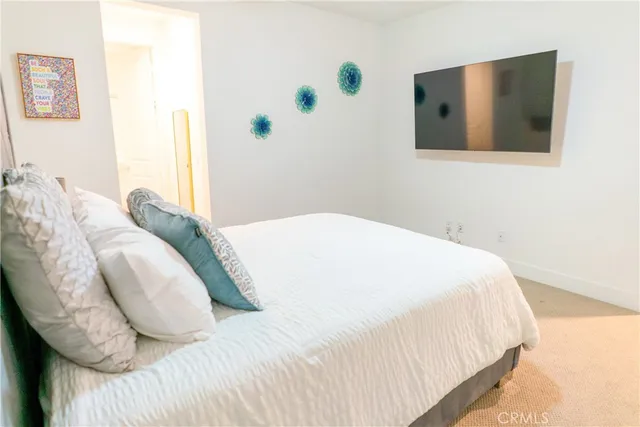 a bedroom with a bed and a painting on the wall