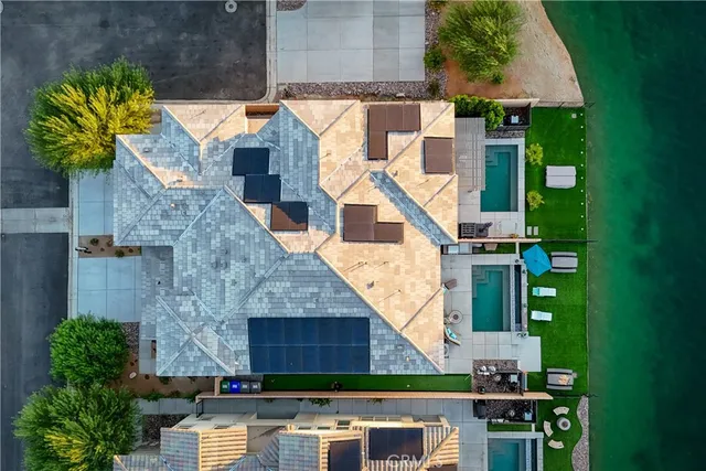 a front view of a house with a garden and lake view