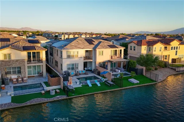 an aerial view of a house with swimming pool a yard and lake view