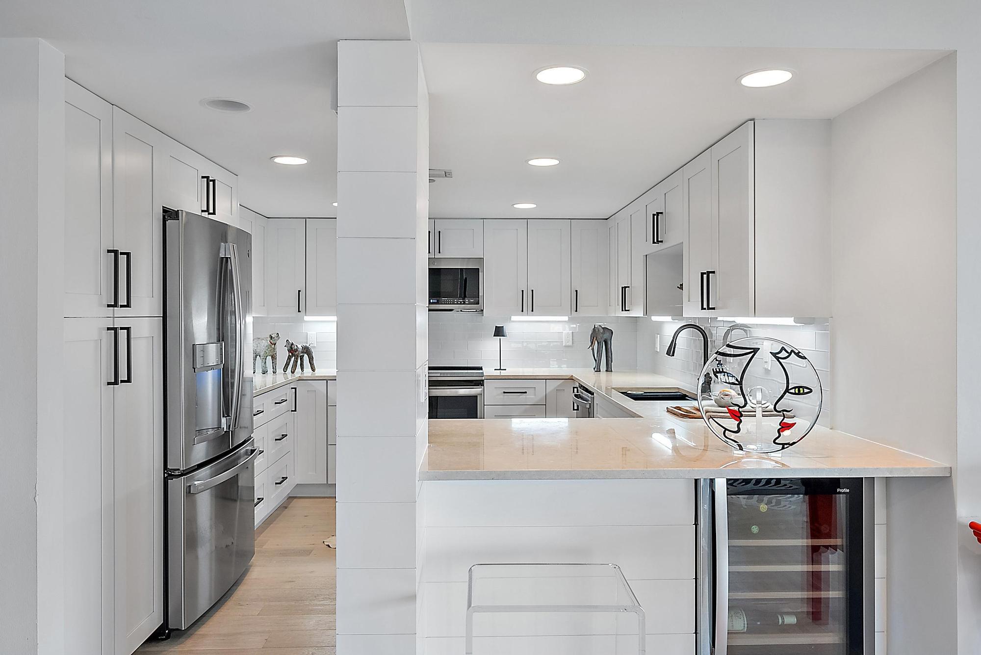 326 Oak Harbour Drive Juno Beach, FL 33408 - Photo 9 of 41 a kitchen with stainless steel appliances a refrigerator sink and cabinets