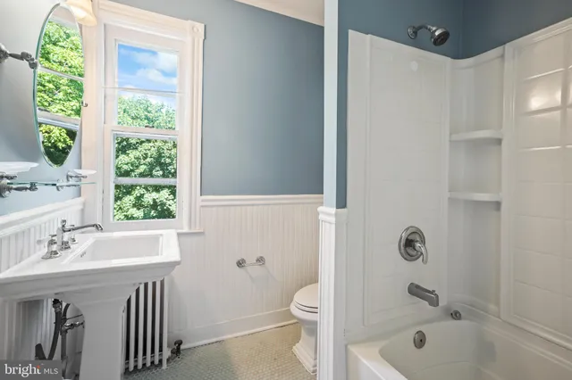 a room with kitchen island a sink and wooden floor