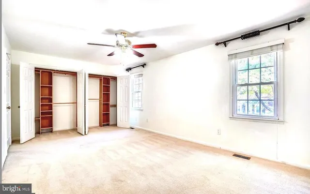a view of a big room with closet and a ceiling fan