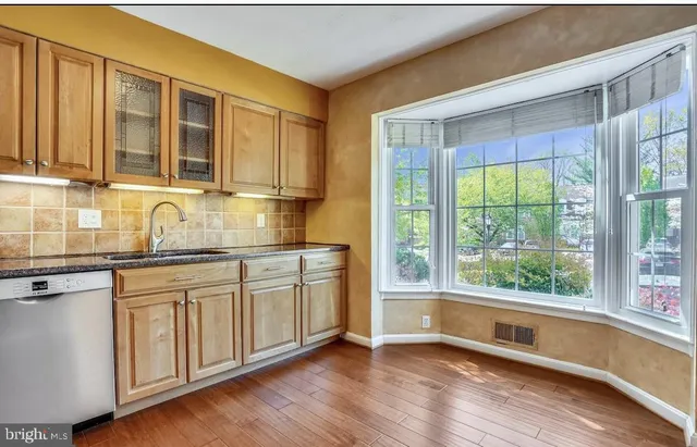 a kitchen with stainless steel appliances a stove and wooden floor