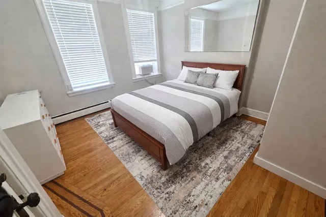 a bedroom with a bed and wooden floor