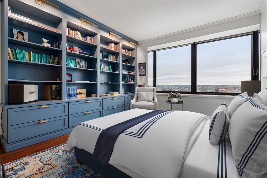 85 East India Row, Unit 19H Boston, MA 02110 - Photo 15 of 23 a bedroom with a bed a large window and book shelf