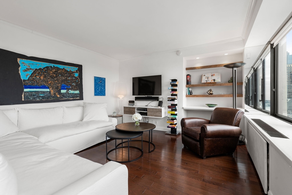 85 East India Row, Unit 19H Boston, MA 02110 - Photo 9 of 23 a living room with furniture and a flat screen tv